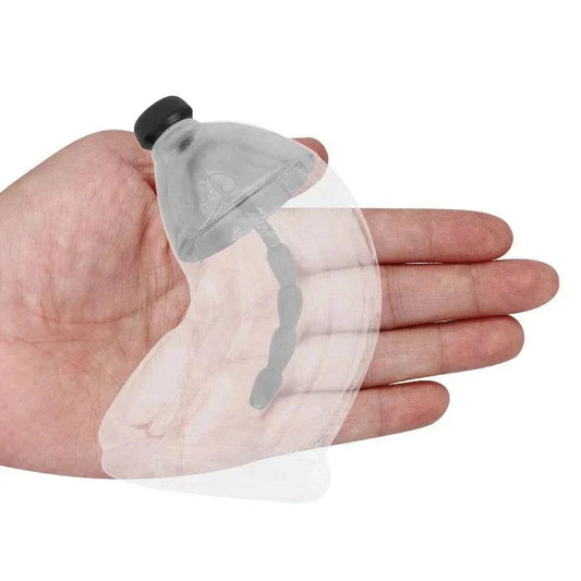 Electric shock penis plug and chastity cage with urethral dilator held in hand for electro stimulation and restraint play.