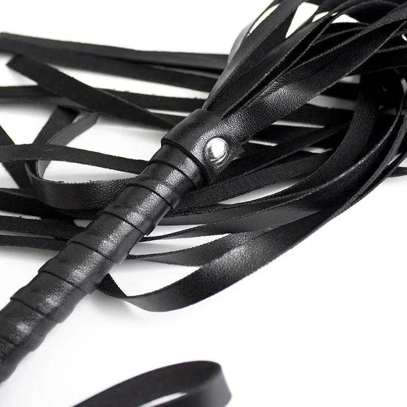 Black leather flogger whip with multiple strands for sensory play and bondage.