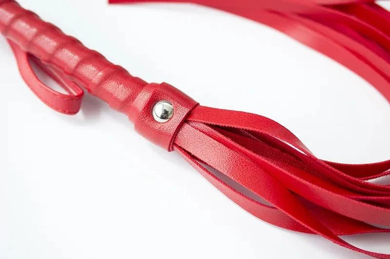 Close-up of red leather flogger whip for sensory play and bondage set