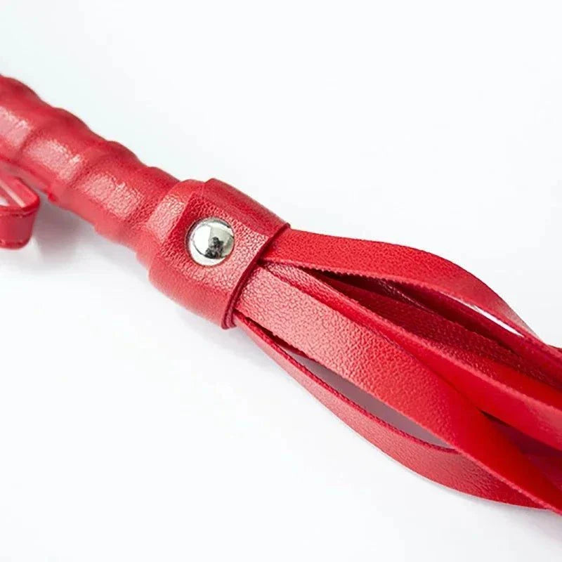 Red faux leather whip riding crop for BDSM impact play with firm handle and flexible flogger strands