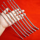 Curved stainless steel urethral insert penis plugs with beaded shafts displayed on hand