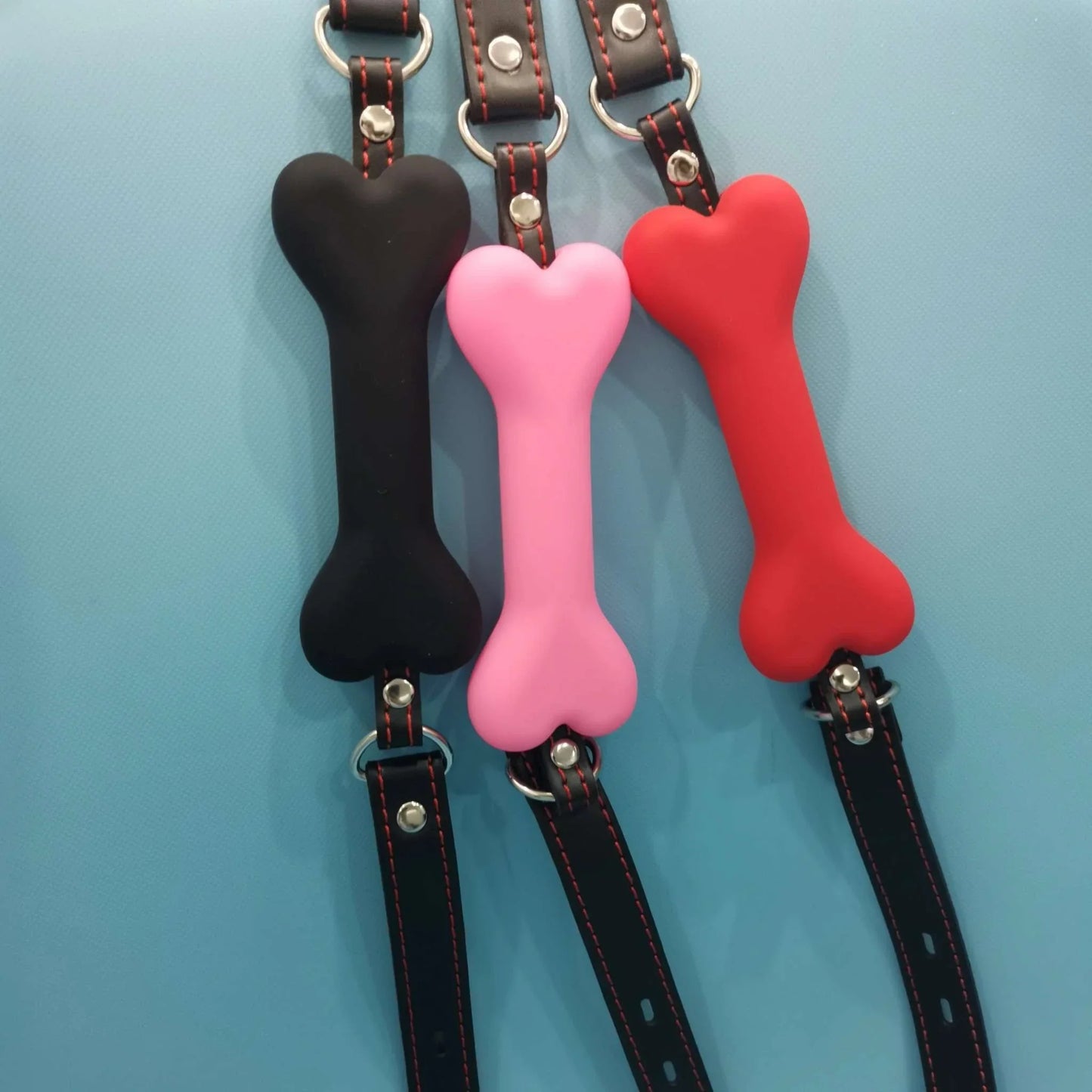 Soft Harness Mouth silicone dog-bone ball gags in black, pink, and red with adjustable straps for bondage restraint